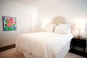 A bedroom with a bed, bedside tables, a lamp, a door, and a colorful abstract painting on the wall. - Luxurious Property in the Heart of Oxford (Oxford)