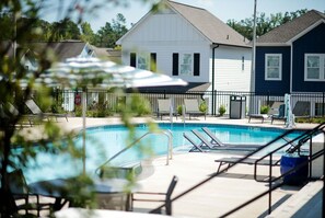 A swimming pool with lounge chairs and a fence, surrounded by houses. - Luxurious Property in the Heart of Oxford (Oxford)