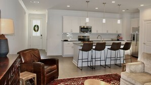 A modern kitchen with white cabinets, stainless steel appliances, and bar stools. - Luxurious Property in the Heart of Oxford (Oxford)