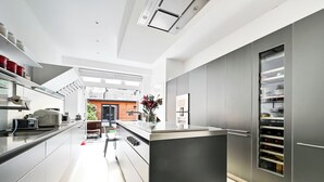 Una cocina moderna con una isla central, electrodomésticos integrados y vistas al exterior.