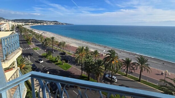 A coastal cityscape with a beach, palm trees, and a road leading to the beach. - Apartament with sea wiev (Nice)