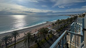 A coastal cityscape with a beach, palm trees, and a road leading to the beach. - Apartament with sea wiev (Nice)