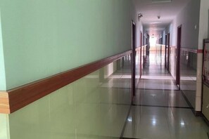 A long, straight corridor with a reflective floor and a wooden baseboard. - Wuhu Tiandu Express Hotel (Wuhu)