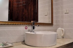 A bathroom with a round white sink, a mirror above it, and a wooden cabinet. - Wuhu Tiandu Express Hotel (Wuhu)