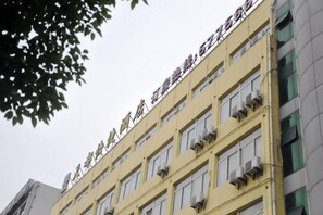 Un immeuble à plusieurs étages, doté d’une façade jaune et de nombreuses fenêtres.