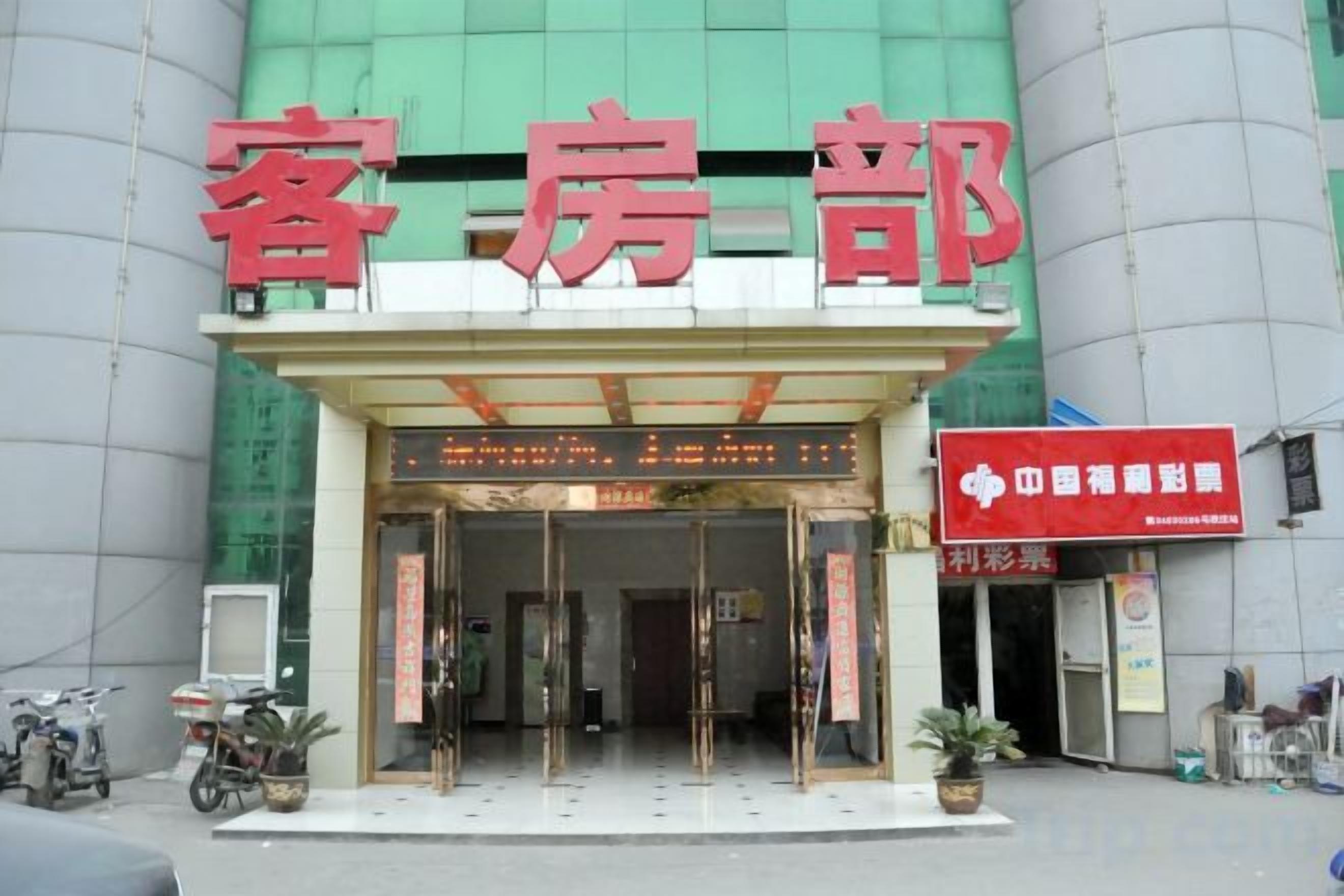 A hotel entrance with a sign reading 'HOTEL' and a red banner with white text.