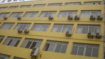 Un edificio de varios pisos con numerosas ventanas y unidades de aire acondicionado.