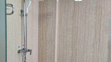 A shower with a handheld showerhead and a wall-mounted faucet.