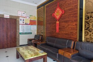A lobby with a reception desk, seating area, and informational posters. - Wuhu Tiandu Express Hotel (Wuhu)