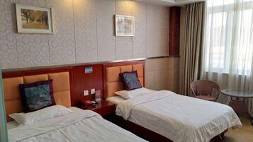 Une chambre d’hôtel avec deux lits, une petite table et une chaise.