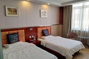 A hotel room with two beds, a small table, and a chair. - Wuhu Tiandu Express Hotel (Wuhu)