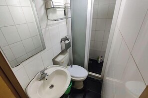 A small bathroom with a sink, toilet, and a mirror. - Jinying Hostel (Shanghai)