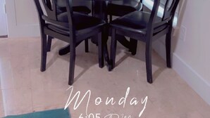 A dining area with a round table and four chairs.