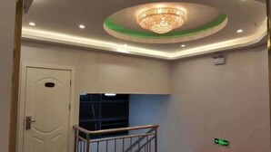 A hotel room with a chandelier, a door, a staircase, and a red carpet. - Xiangfu Hotel (Shanghai Guoding Road) (Shanghai)