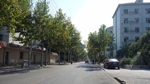 A street with buildings, trees, and parked cars. - Xiangfu Hotel (Shanghai Guoding Road) (Shanghai)