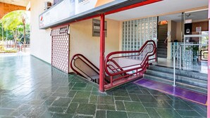 A hotel entrance with a red metal staircase leading to a reception area.