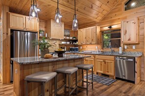 A modern kitchen with wooden cabinets, stainless steel appliances, and a granite countertop.
