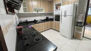 Une cuisine moderne équipée d’une cuisinière à gaz, d’un four à micro-ondes et d’un réfrigérateur.