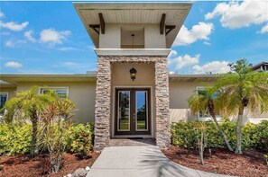 Stunning entrance with a beautifully maintained garden and palm trees.