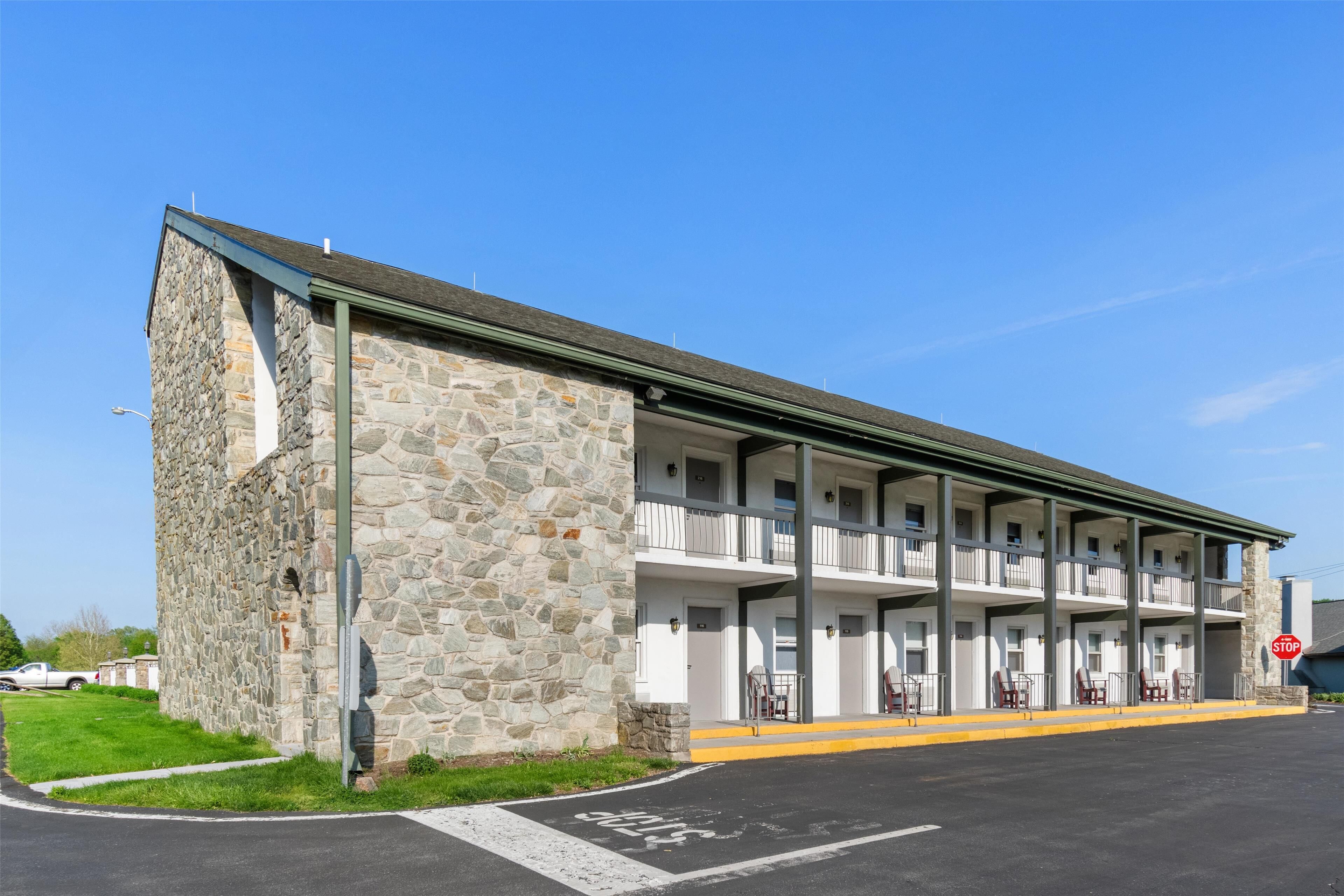 A two-story motel with a stone facade and a flat roof.