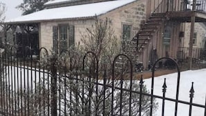 A stone building with a snow-covered roof and a satellite dish.