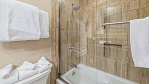 Une salle de bain moderne avec une douche à parois de verre, une baignoire et des toilettes.