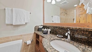 A bathroom with a granite countertop, a sink, a mirror, and a towel rack. - Lodge Tower 293  at the base of Vail Mountain (Vail)