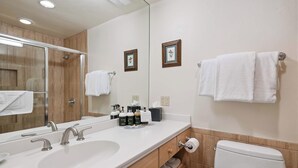 Une salle de bain moderne avec un grand miroir, deux lavabos, des toilettes et un porte-serviettes.