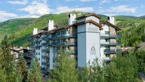 A multi-story hotel with balconies, set against a mountainous backdrop. - Lodge Tower 390  at the base of Vail Mountain (Vail)