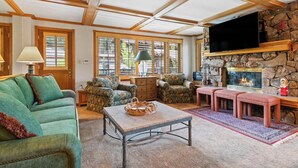 A cozy living room with a stone fireplace, comfortable seating, and large windows. - Lodge Tower 599 1BR  at the base of Vail Mountain (Vail)