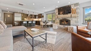 Un salón espacioso con chimenea, comedor y cocina al fondo.