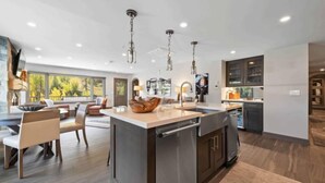Una cocina moderna con una isla central, electrodomésticos de acero inoxidable e iluminación colgante.