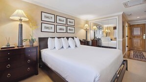 A hotel room with a large bed, a dresser, a lamp, and framed pictures on the wall. - Lodge Tower 690  at the base of Vail Mountain (Vail)