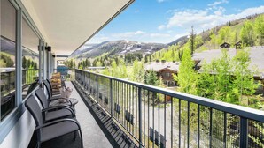 A balcony with outdoor seating and a scenic mountain view.