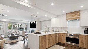 A modern kitchen with wooden cabinets, stainless steel appliances, and a large island. - Lodge Tower 278 1BR at the base of Vail Mountain (Vail)