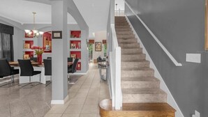 Ein modernes Interieur mit Treppe, Essbereich und Wohnraum.