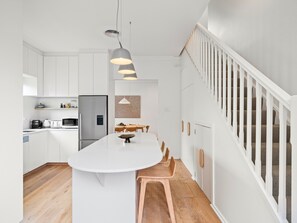 Enjoy cooking in this well-equipped kitchen with a central island, stainless steel appliances, and ample dining space.