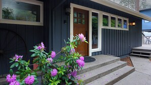 A building with a wooden door, a window, and steps leading to the entrance. - Kokanee Bay Beach House Lake Coeur d'Alene! (Coeur d'Alene)