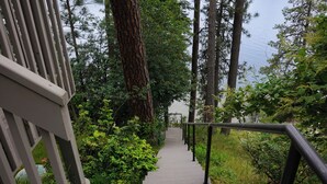 A concrete staircase with metal railings leading up a forested area. - Kokanee Bay Beach House Lake Coeur d'Alene! (Coeur d'Alene)