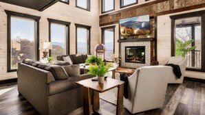 Un salón espacioso con ventanas amplias, una chimenea y una zona de estar confortable.