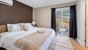 Une chambre d’hôtel avec un grand lit, une fenêtre avec des rideaux, un luminaire au plafond et un panneau mural en bois.