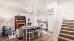 Uma sala de estar moderna com lareira, área de jantar e cozinha.
