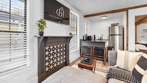 Una sala de estar moderna con chimenea, una zona de cocina y un comedor.