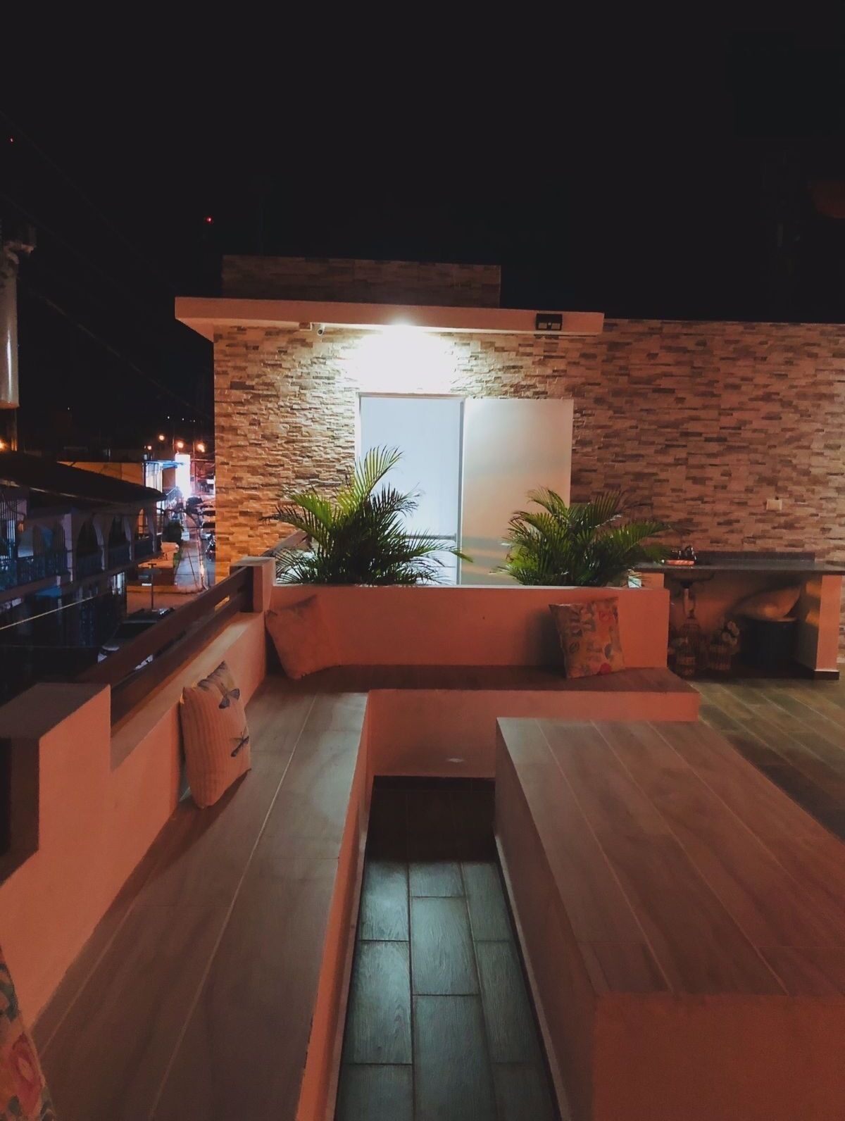 Un espace extérieur moderne, aménagé avec des jardinières intégrées et une petite fontaine.