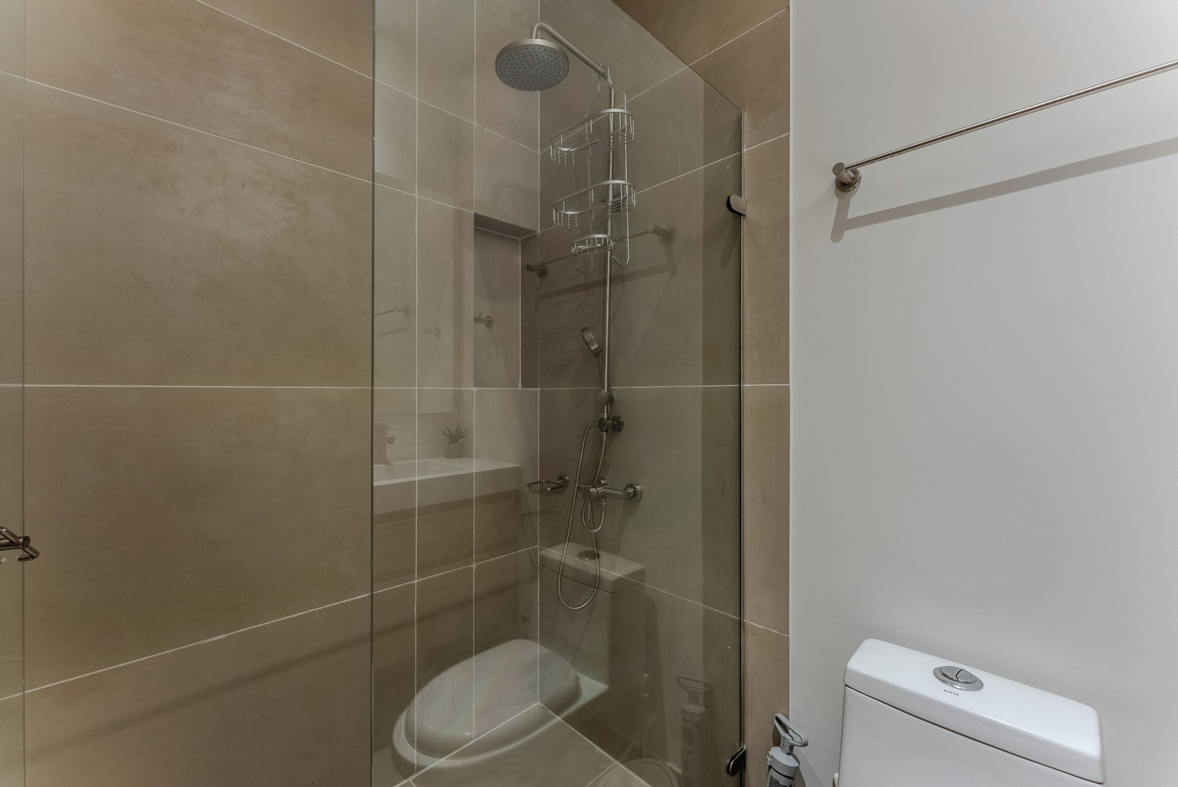 Un bagno moderno con doccia vetro, servizi igienici e lavandino.