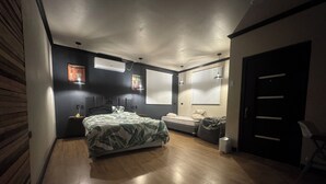 Un dormitorio con cama, escritorio, silla, armario y ventana.