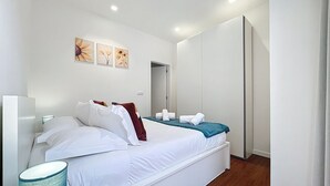 Ein modernes Schlafzimmer mit Bett, Nachttisch, Lampe und Kunstwerk an der Wand.