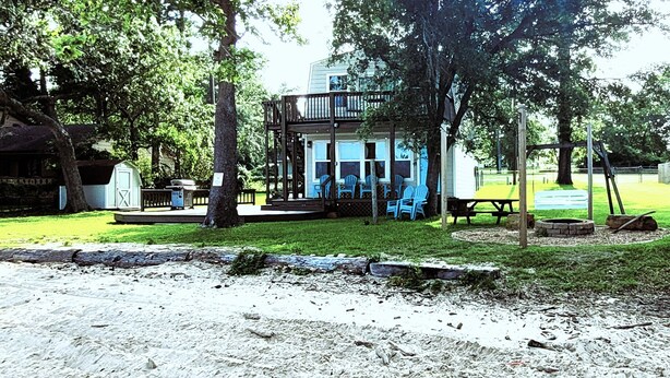 A cabin with a deck, outdoor seating, and a fire pit. - Lakeside Cabin With Your Own Personal Beach and Expansive Lake View (Point Blank)