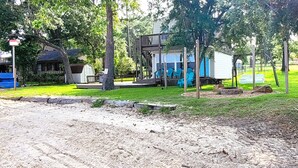 A park with a wooden deck, blue chairs, and a small building. - Lakeside Cabin With Your Own Personal Beach and Expansive Lake View (Point Blank)