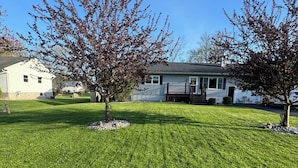 A residential lawn with a house in the background. - 3 Bedroom Ranch with private inground pool just 12 mi. from SPAC and racetrack (Burnt Hills)